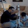 adult and child building a rocket