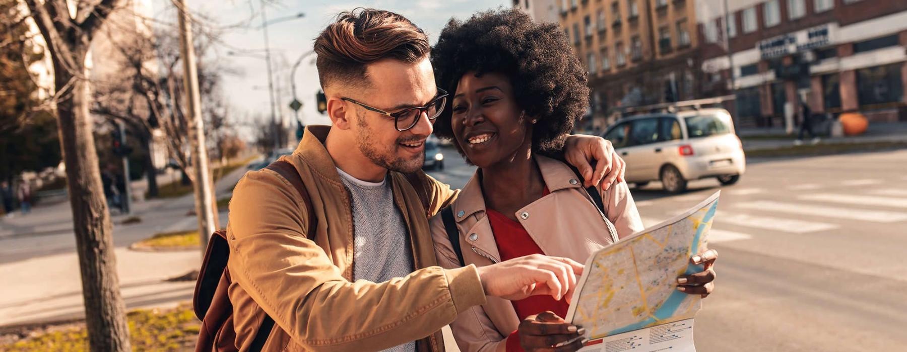 a man and woman looking at a map in the city