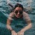 woman with sunglasses swims in pool