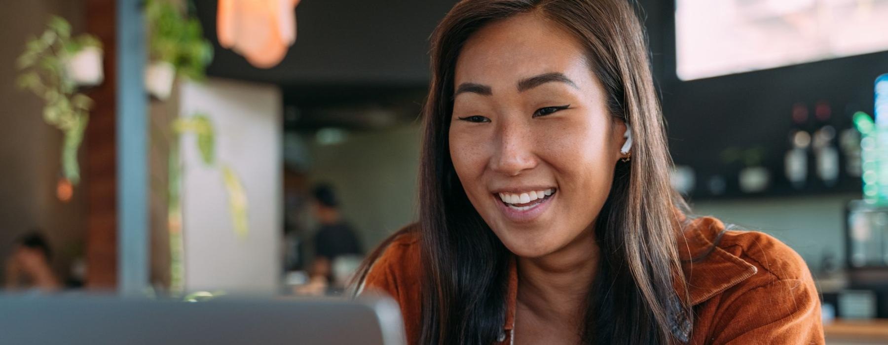 a woman smiling while working on laptop